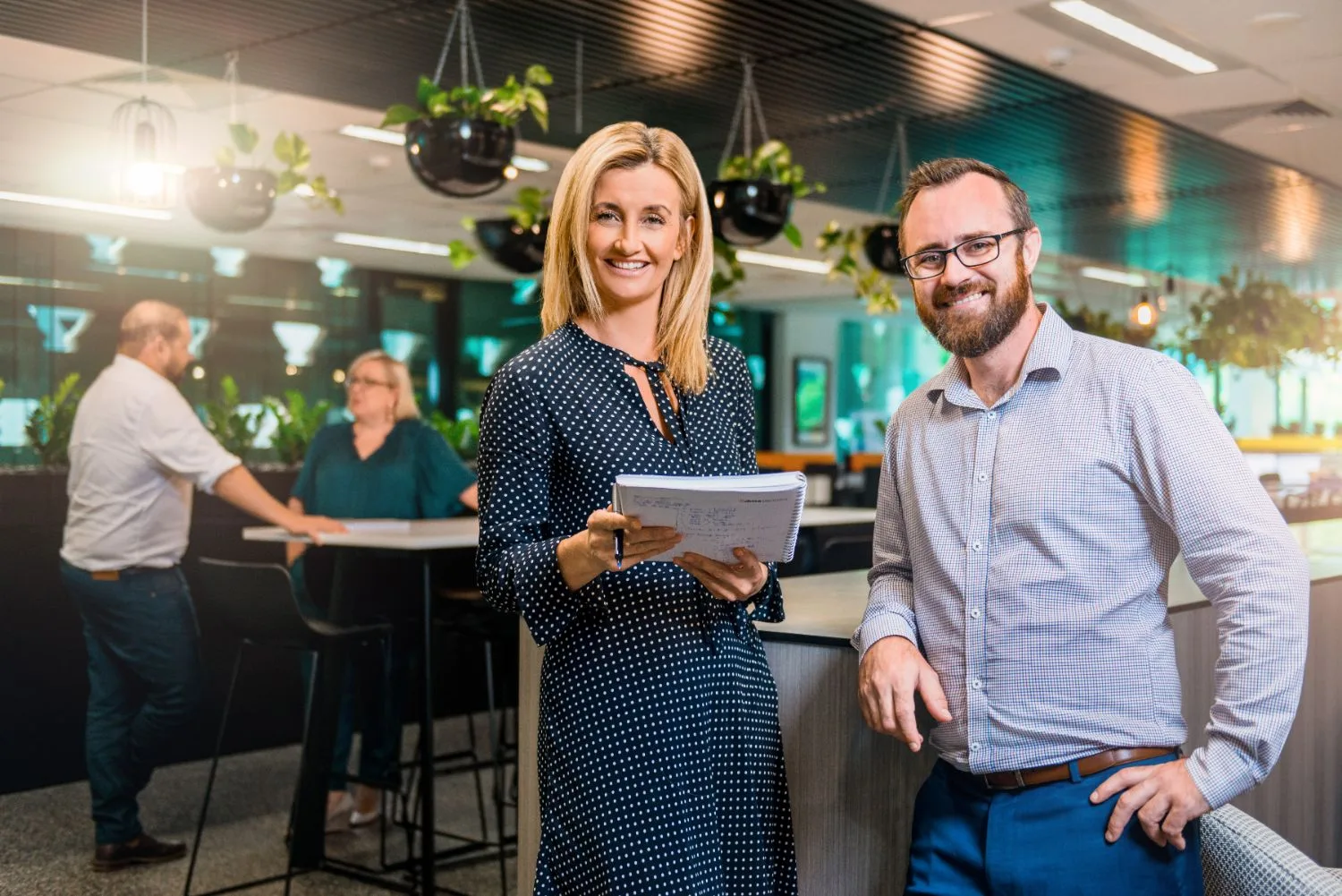 Two colleagues smiling in a modern Brisbane open-plan office