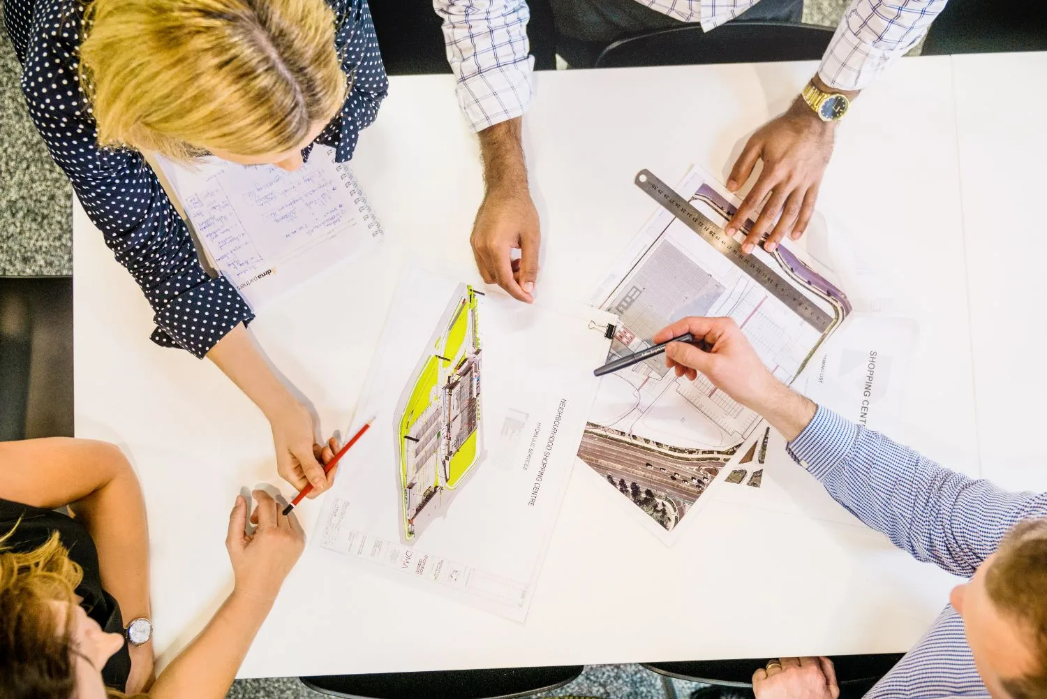Overhead view of a team reviewing plans around a meeting table