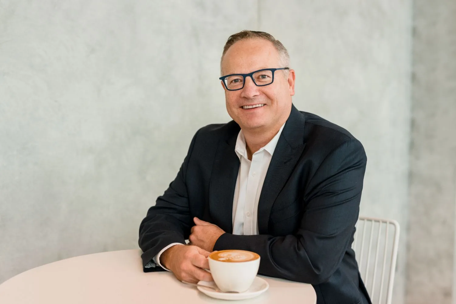Relaxed corporate headshot of a businessman with a coffee