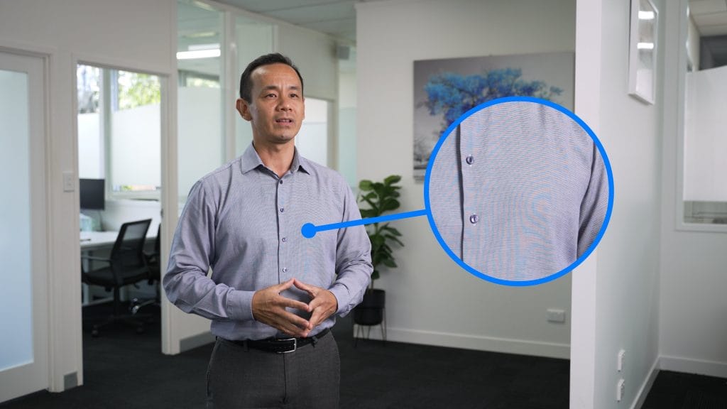 Man presenting in office with close-up on shirt pattern.