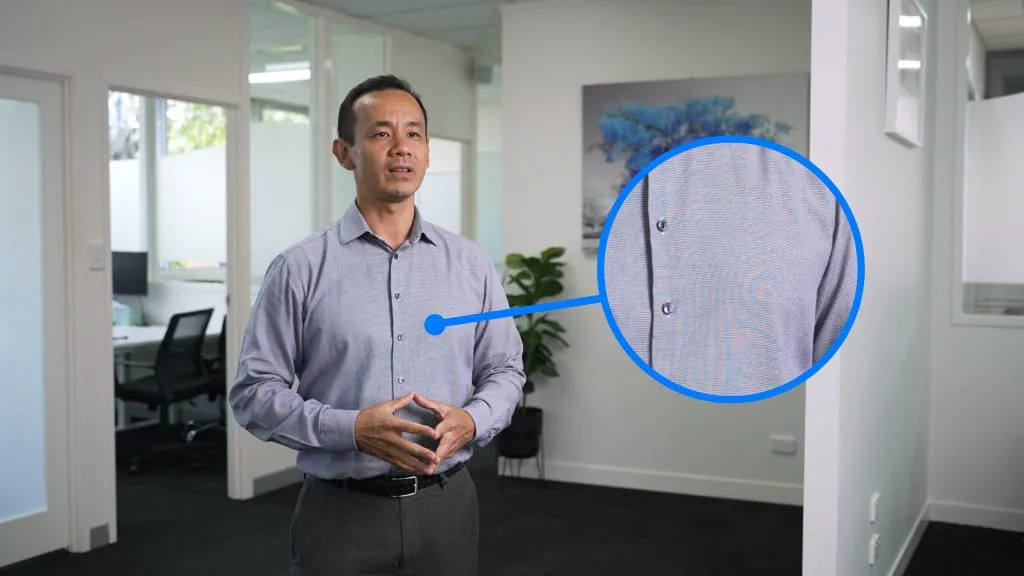 Man presenting in office with close-up on shirt pattern.